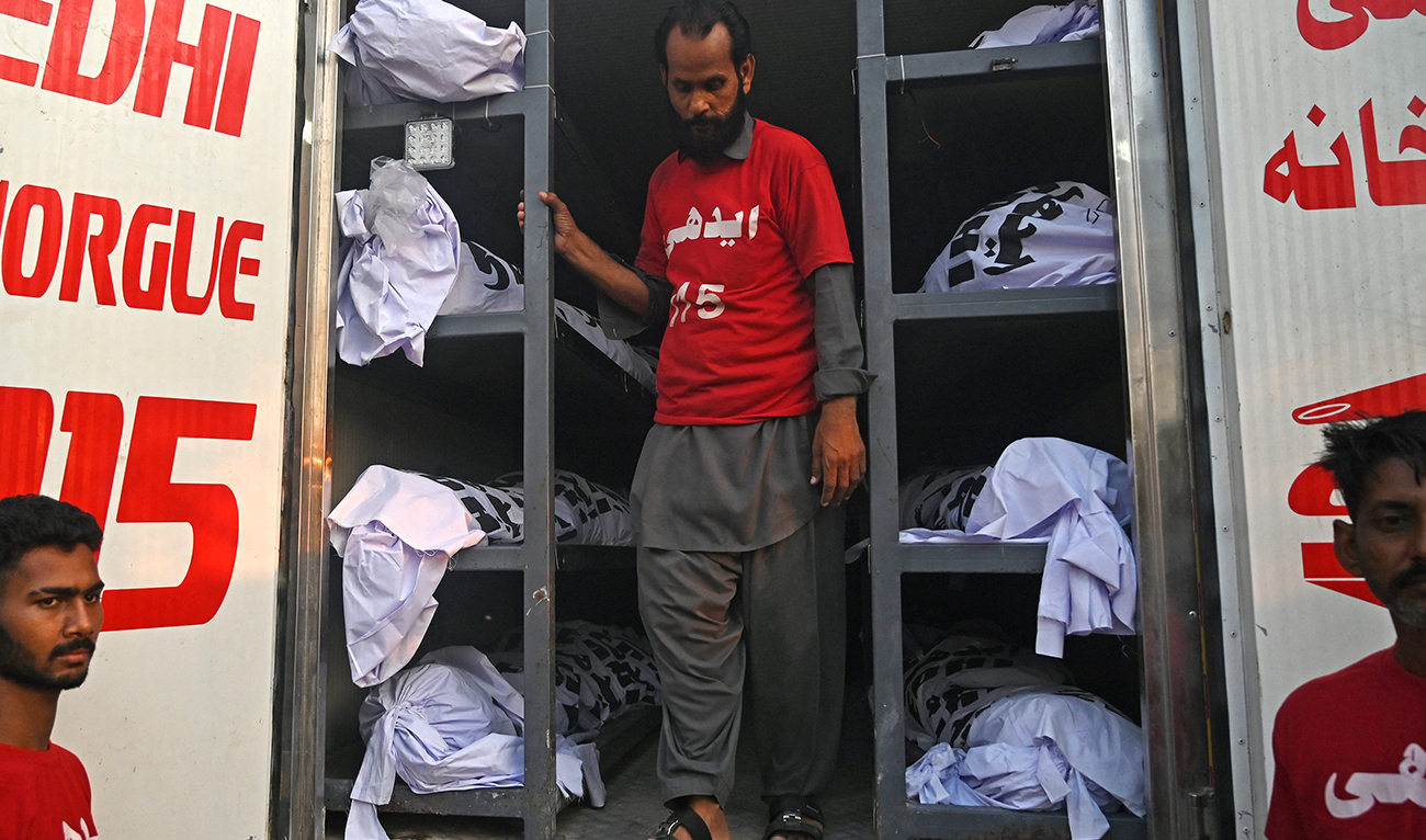 A volunteer prepares to shift the dead bodies of religious pilgrims in a vehicle, after a truck accident, in Karachi on April 11, 2024. (AFP/File)