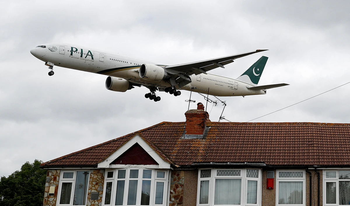 A Pakistan International Airlines Boeing 777 comes in over houses, to land at Heathrow airport in west London as the UK government's planned 14-day quarantine for international arrivals to limit the spread of Covid-19 starts on June 8, 2020. (AFP/File)