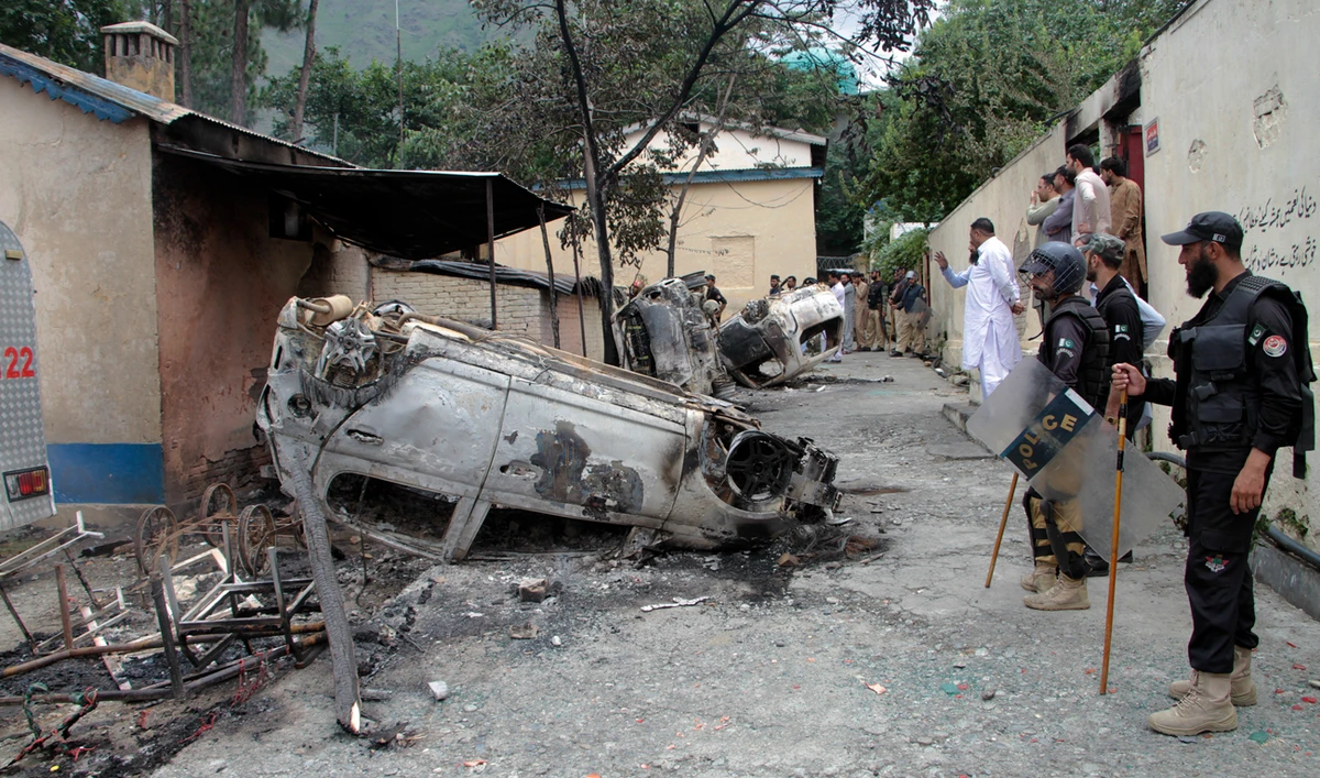 Police officers examine burnt vehicles which were torched by a Muslim mob in an attack, in Madyan in Pakistan’s Khyber Pakhtunkhwa province on June 21, 2024. (AP)