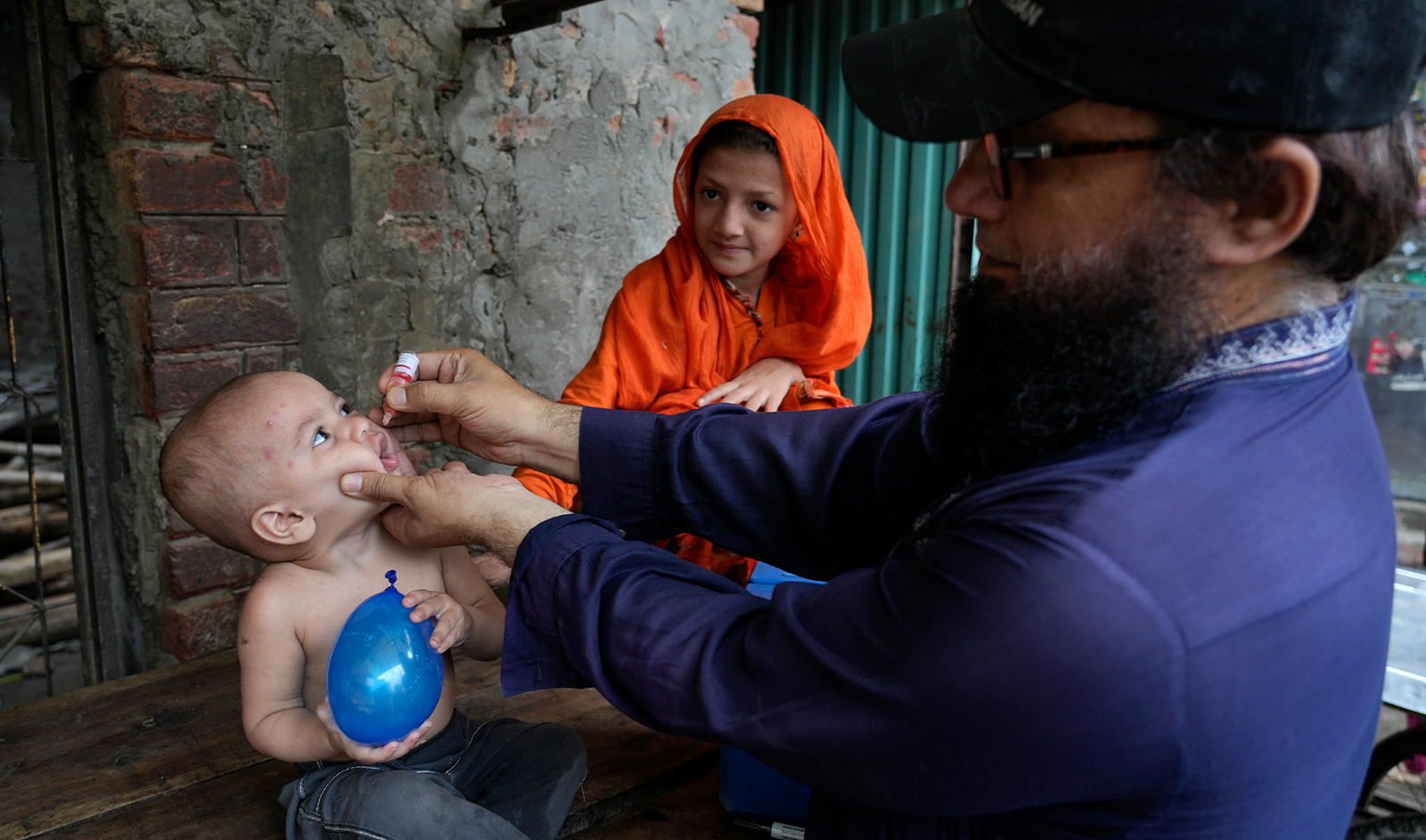 A health worker administers a polio vaccine to a child in a neighborhood of Lahore, Pakistan, on July 1, 2024. (AP)