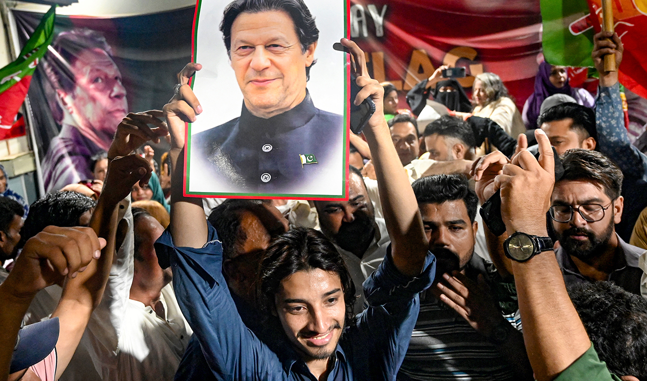 Supporters of Pakistan's jailed former Prime Minister Imran Khan hold his poster as they celebrate after he was aquitted of leaking state secrets following a court verdict in Karachi on June 3, 2024. (AFP/File)