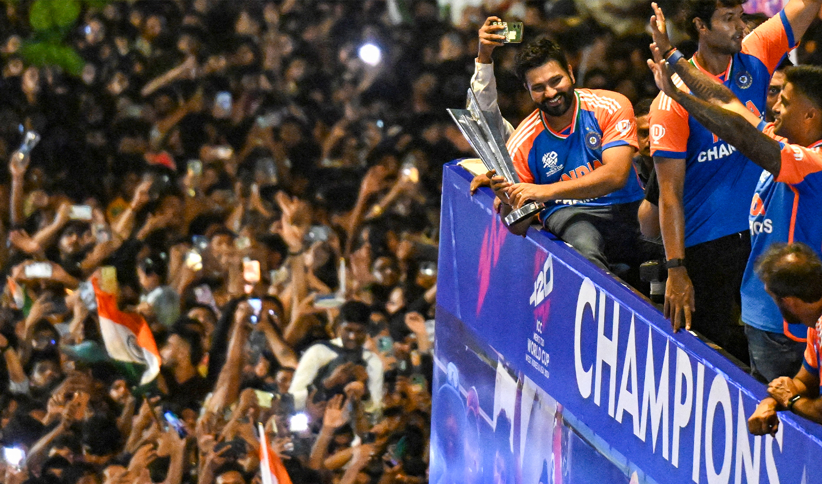 Indian cricket captain Rohit Sharma holds the trophy as he greets fans during an open bus roadshow in Mumbai on July 4, 2024, after winning the ICC men's Twenty20 World Cup in Barbados. (AFP/File)