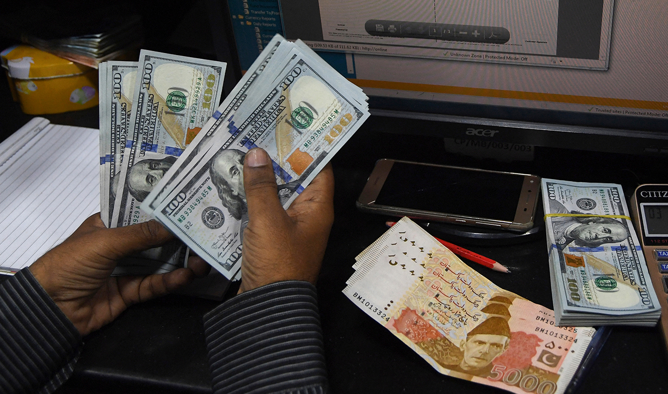 In this picture taken on April 15, 2019, a Pakistani dealer counts US dollars at a currency exchange shop in Karachi. (AFP/File)