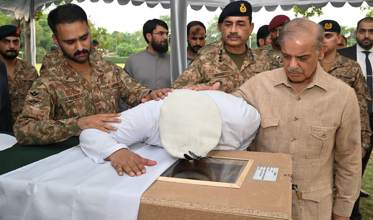 In this handout photo, taken and released by Pakistan’s Inter-Service Public Relations (ISPR), Pakistan Prime Minister Shehbaz Sharif (R) and Chief of Army Staff of Pakistan Asim Munir (2R) console father of Captain Muhammad Osama bin Arshad as he reacts by the body of his son, who was killed in a gunfight in North Waziristan early Tuesday, during funeral prayers in Rawalpindi on July 9, 2024. (Photo courtesy: ISPR)