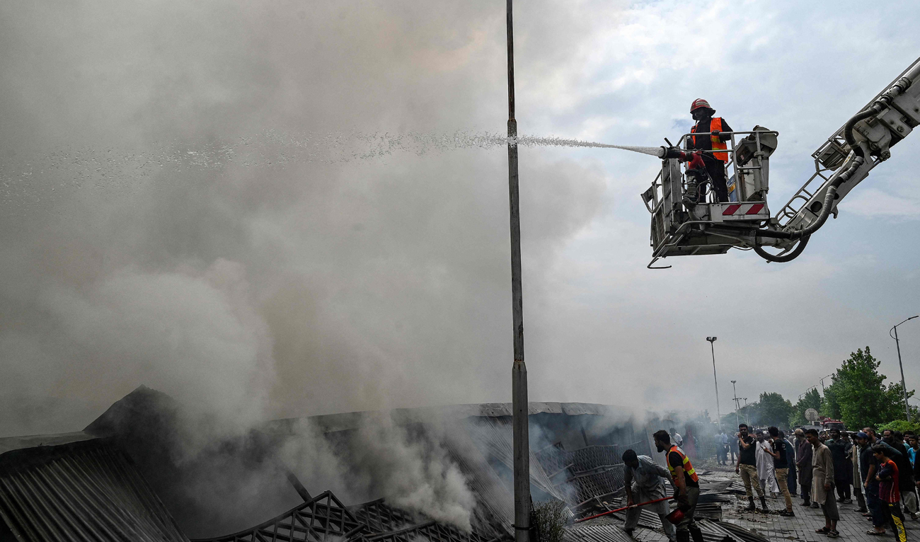 Firefighters try to extinguish a fire that erupted at a weekly market in Islamabad on July 10, 2024. More than 100 shops were gutted in the fire that broke out in a weekly market in the Pakistani capital Islamabad on July 10, officials and local media reports. (AFP)