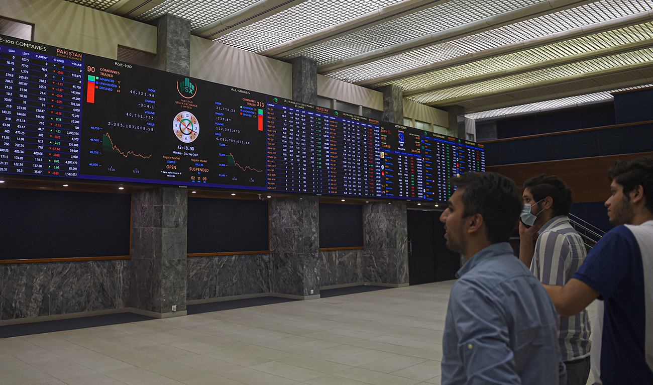 Stockbrokers watch an index board showing the latest share prices during a trading session at the Pakistan Stock Exchange (PSX) in Karachi on September 20, 2021. (AFP/File)