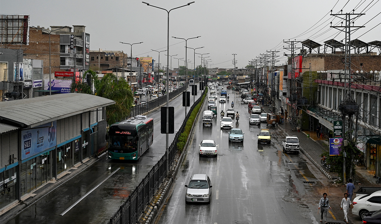 Commuters ride along a street after rainfall in Peshawar on June 5, 2024. (FP/File)