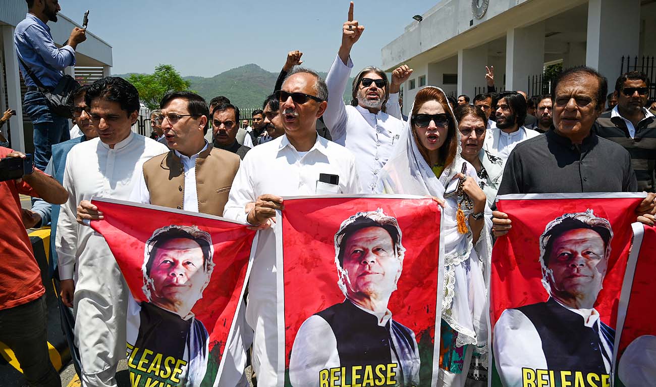 Parliamentarians of the Pakistan Tehreek-e-Insaf (PTI) party, carry posters of jailed former prime minister Imran Khan, during a protest outside the Parliament house in Islamabad on July 18, 2024. (AFP)