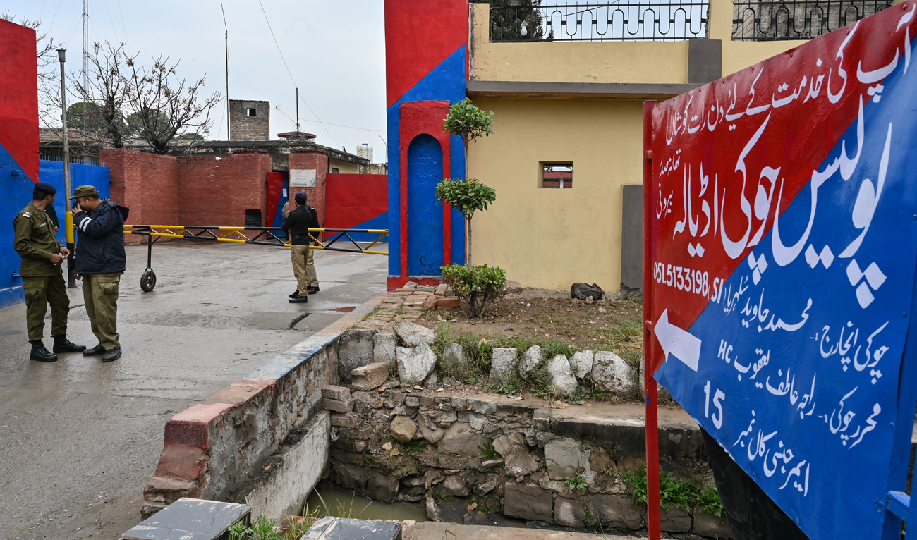 Police personnel stand guard near a signboard reading ‘police check post Adiala’ at the entrance of Adiala jail after the hearing of Pakistan’s jailed former Prime Minister Imran Khan in Rawalpindi on January 31, 2024. (AFP/File)