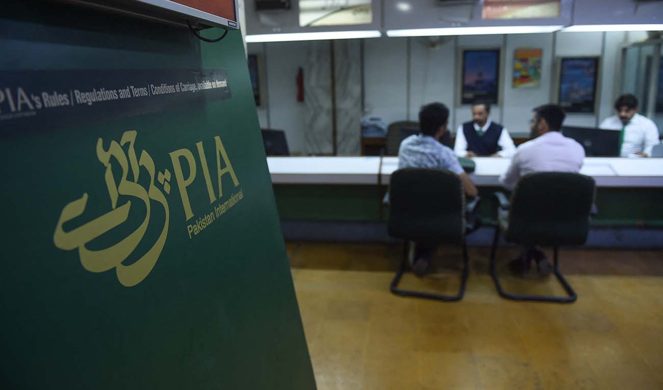 Staff of Pakistan International Airlines (PIA) talk with passengers at a PIA office in Karachi on February 27, 2019. (AFP/File)