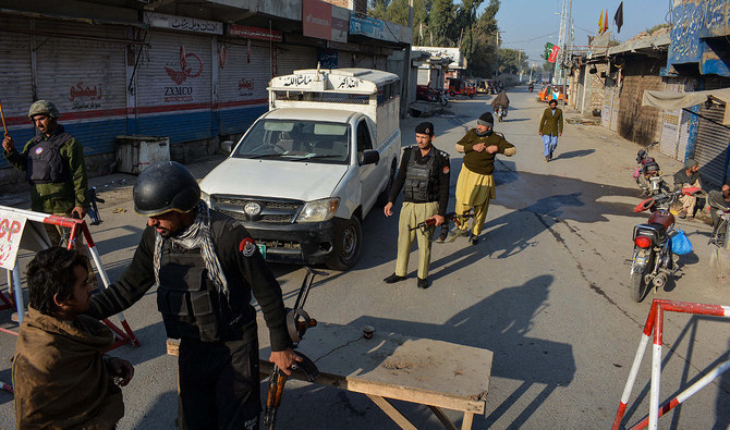 In this photo taken on December 19, 2022, police stand guard along a road they blocked after Taliban militants seized a police station in Bannu. (AFP/File)