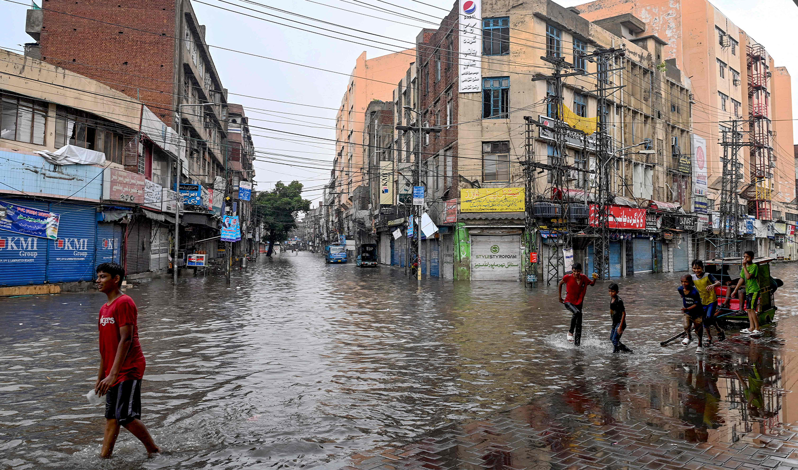 People wade through a flooded street amid heavy rainfall in Lahore on July 28, 2024. (AFP)