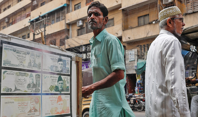 People walk past a sidewalk money exchange showcase, which is decorated with pictures of currency notes, in Karachi, Pakistan on September 12, 2023. (REUTERS/File)