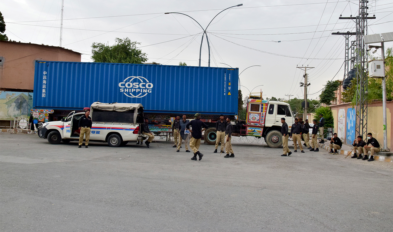 Police officers guard a road blocked by a shipping container and truck in Quetta, Pakistan on July 29, 2024. (AP)