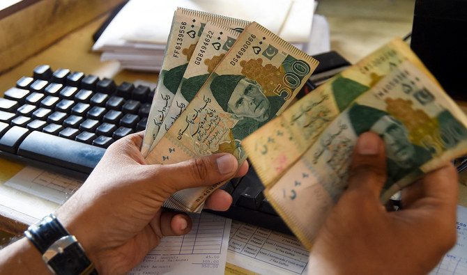 A Pakistani man counts Pakistan's rupees at his shop in Karachi on May 16, 2019. (AFP/File)
