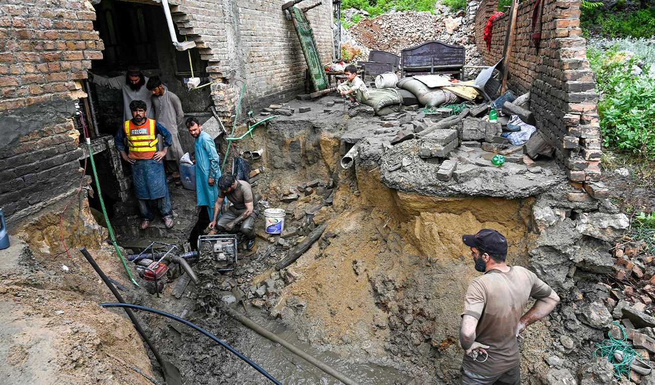 Rescue workers clean the basement of a house damaged by flash flood waters in Darra Adamkhel, Khyber Pakhtunkhwa province of Pakistan, on July 30, 2024. (AFP)