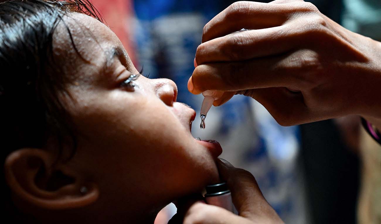 A health worker administers polio vaccine drops to a child during a polio vaccination campaign in Karachi on June 3, 2024. (AFP)