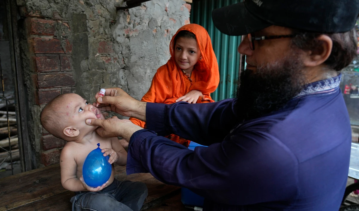 A health worker administers a polio vaccine to a child in a neighborhood of Lahore, Pakistan, on July 1, 2024. (AP)