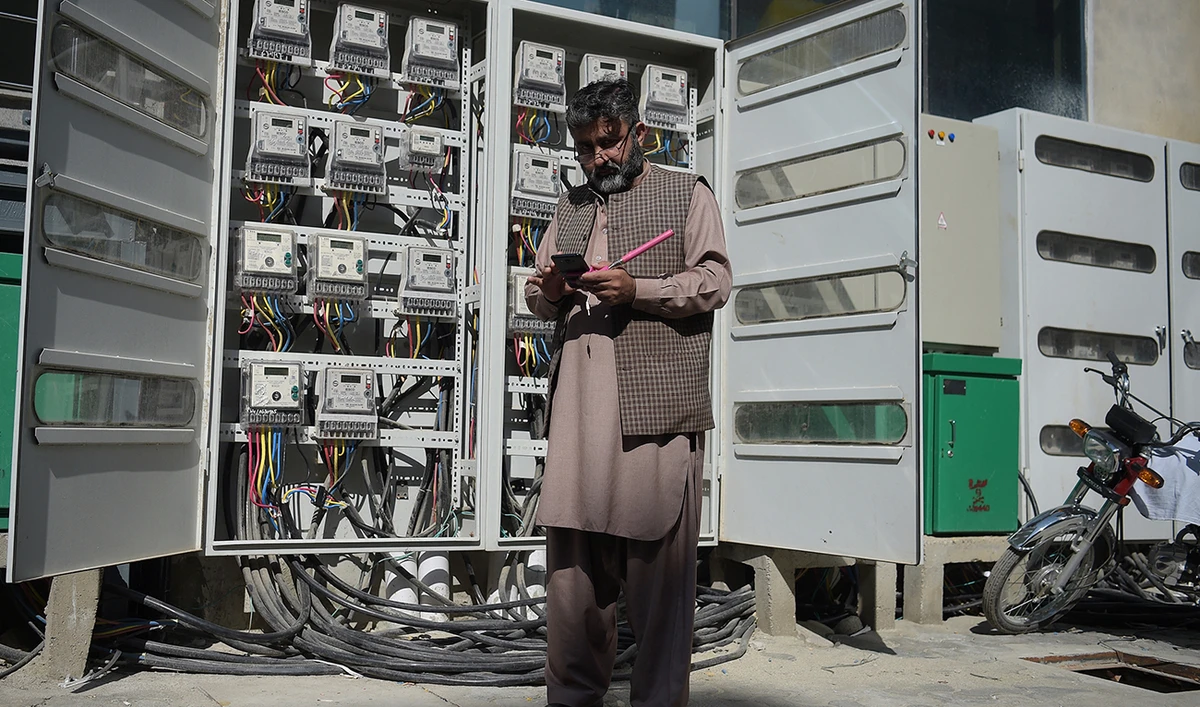 Muhammad Noshad, a Pakistani employee of the state-run Islamabad Electric Supply Company (IESCO), takes a meter reading with his smartphone at a commercial building in Islamabad on November 7, 2018. (AFP/File)