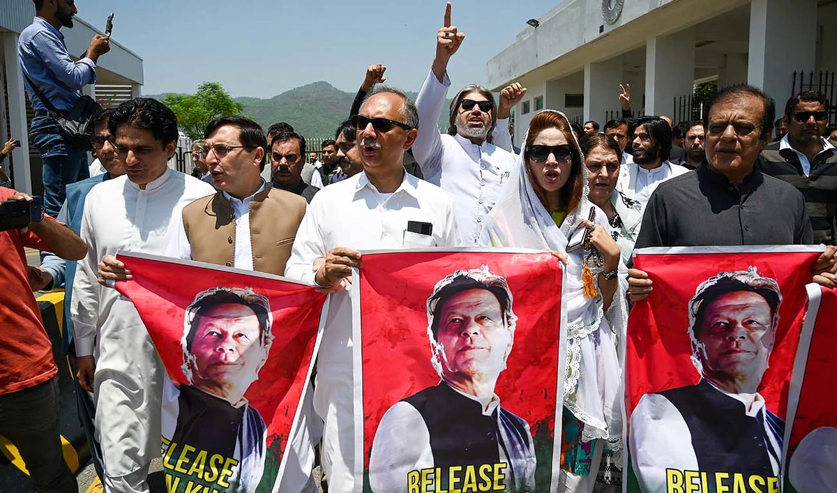 Parliamentarians of the Pakistan Tehreek-e-Insaf (PTI) party, carry posters of jailed former prime minister Imran Khan, during a protest outside the Parliament house in Islamabad on July 18, 2024. (AFP)