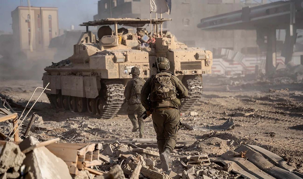 This handout picture released by the Israeli army on July 22, 2024, shows Israeli soldiers behind an armoured vehicle during military operations in the Gaza Strip amid the ongoing conflict between Israel and Hamas. (AFP)