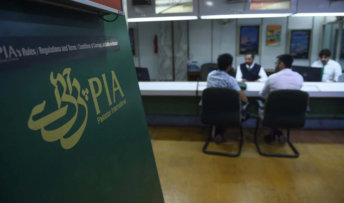 Staff of Pakistan International Airlines (PIA) talk with passengers at a PIA office in Karachi on February 27, 2019. (AFP/File)
