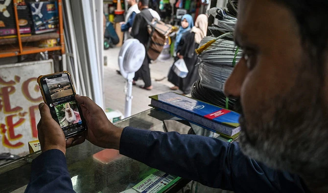 A man uses the social media platform X, formerly known as Twitter, on his phone at a market in Islamabad on April 17, 2024. (AFP/File)