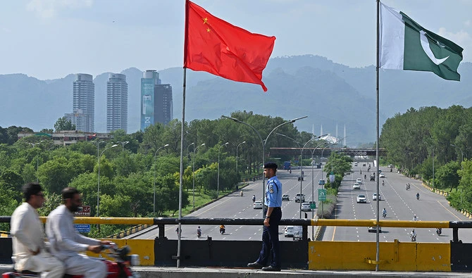 In this file photo, taken on July 30, 2023, a policeman stands guard under the national flags of China and Pakistan along a road, during the visit of Chinese Vice Premier He Lifeng last month, in Islamabad. (AFP/File)