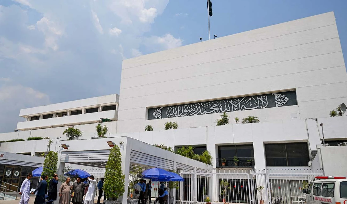 People stand outside the Parliament house during a budget session in Islamabad on June 26, 2024. (AFP/File)