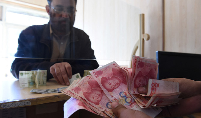 In this file photo, taken on January 3, 2018, a Pakistani currency dealer counts Chinese currency for his customer at his shop in Quetta. (AFP/File)