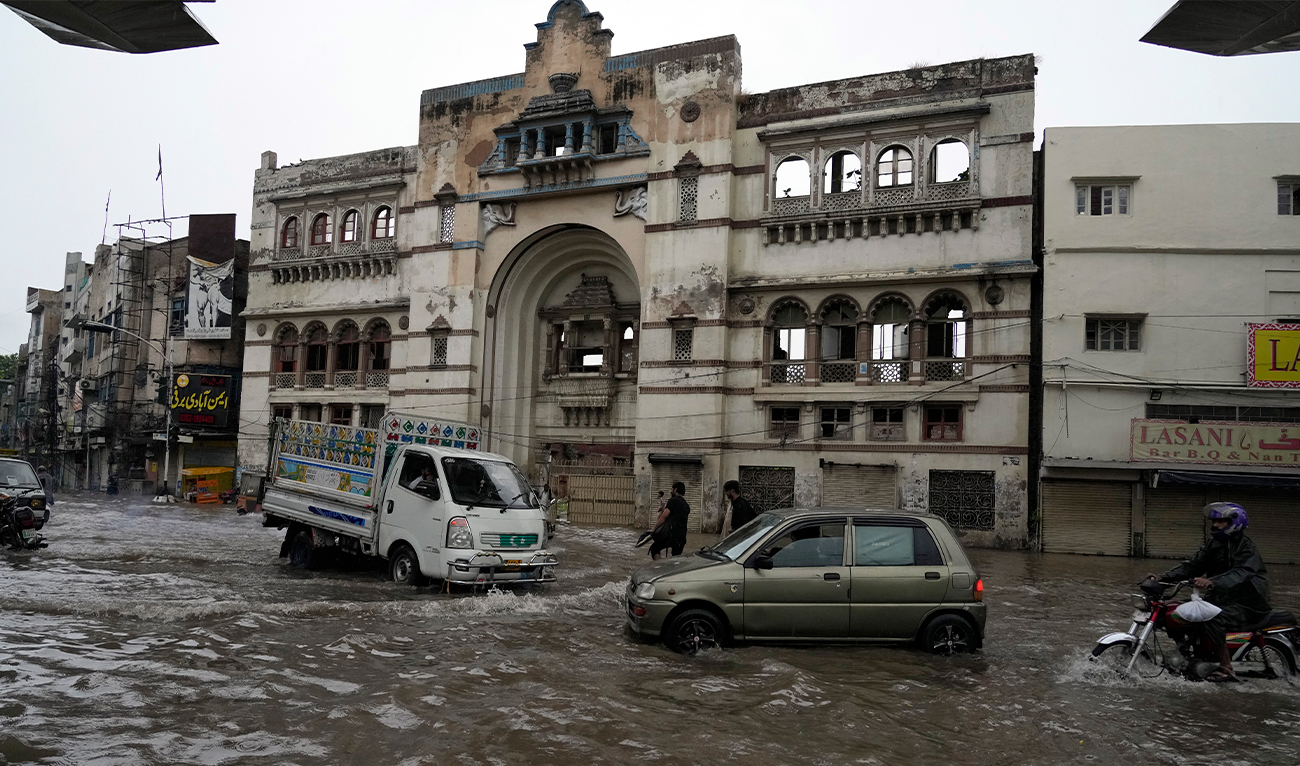Motorcyclists and cars drive through a flooded road caused by heavy monsoon rainfall in Lahore, Pakistan, on August 1, 2024. (AP)
