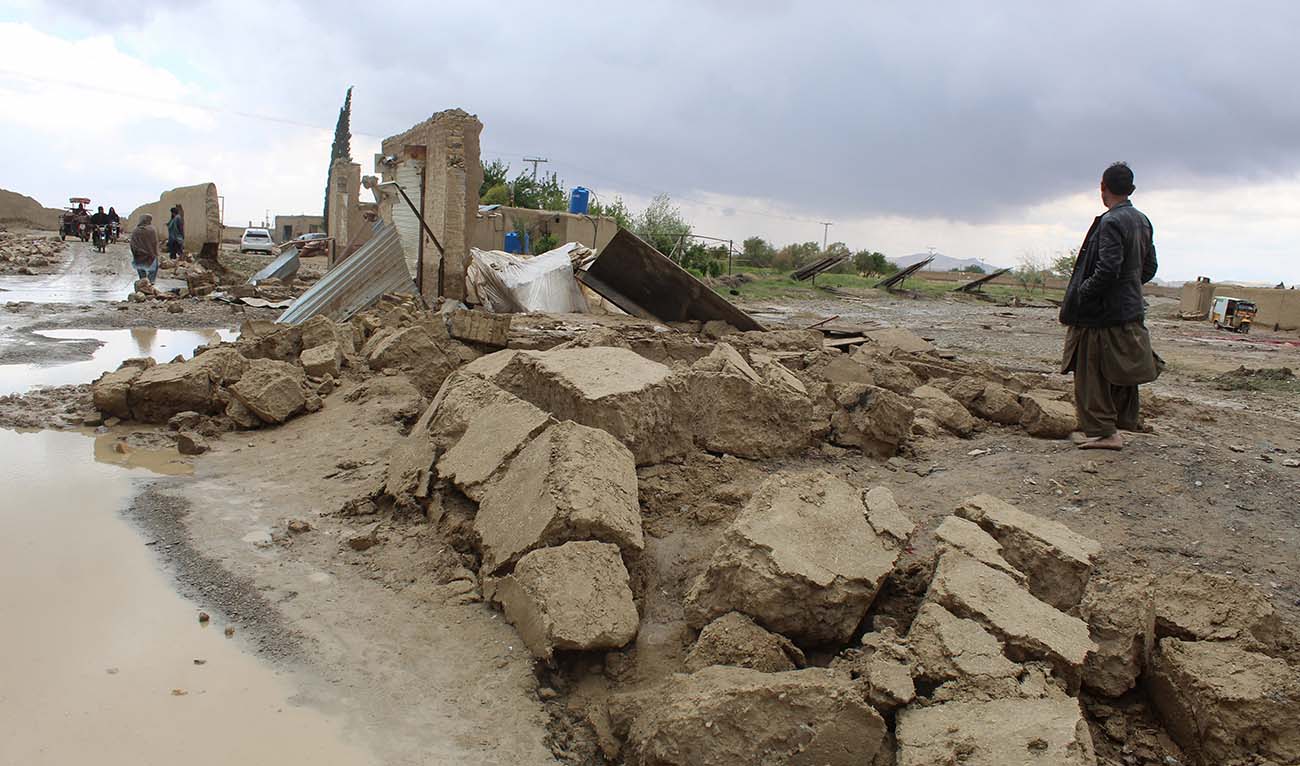 Residents gather beside a damaged house after heavy rains on the outskirts of Chaman in Balochistan province on April 19, 2024. (AFP/File)