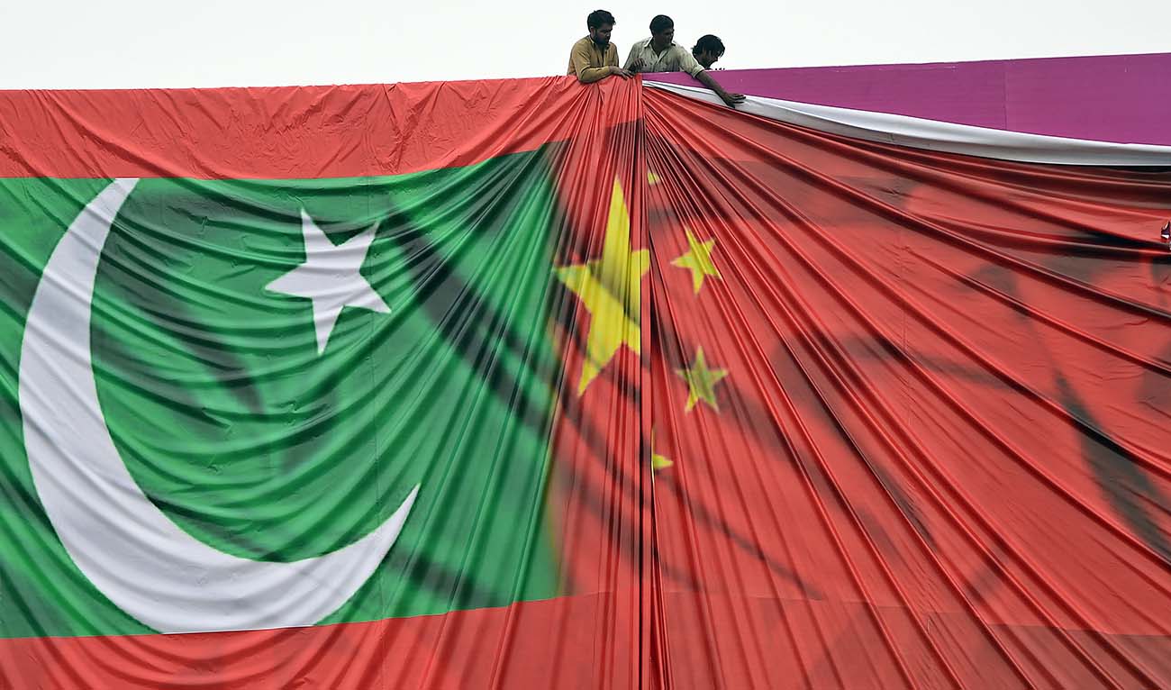 Pakistani labourers arrange a welcome billboard featuring the Chinese and Pakistani national flags ahead of the forthcoming visit by Chinese President Xi Jinping in Islamabad on April 18, 2015. (AFP/File)