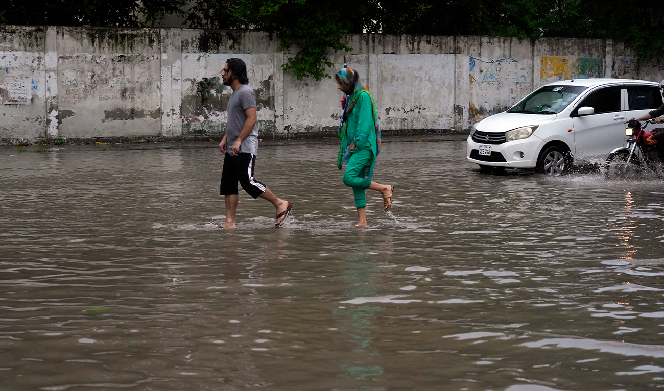 People walk through a flooded road caused by heavy monsoon rainfall in Lahore, Pakistan, on August 11, 2024. (AP/File)