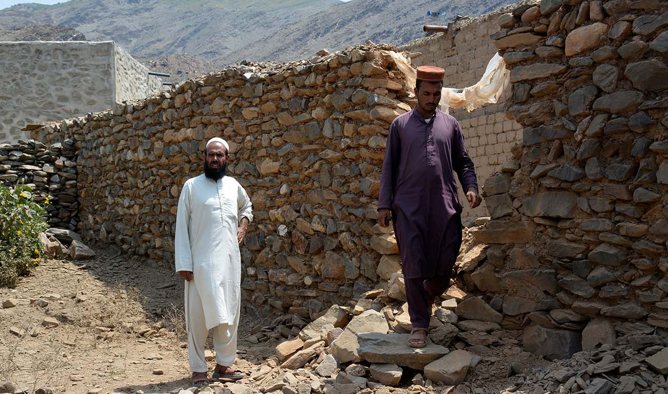 Local residents stand beside a wall damaged due to cross firing between Pakistan and Afghan Taliban forces near Torkham border area of Nangarhar, province east of Kabul, Afghanistan, Tuesday, Aug. 13, 2024. (Reuters)