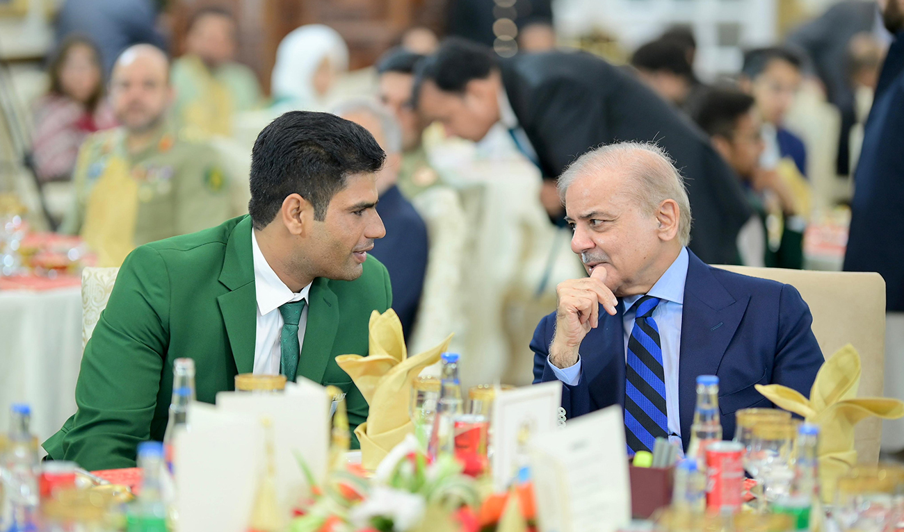 Prime Minister Shehbaz Sharif (R) speaks with Pakistani javelin hero Arshad Nadeem during a dinner ceremony held in Islamabad in honor of the athlete, on August 13, 2024. (PMO)