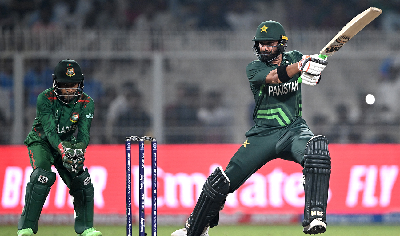 Pakistan's Iftikhar Ahmed (R) plays a shot as Bangladesh's wicketkeeper Mushfiqur Rahim watches during the 2023 ICC Men's Cricket World Cup one-day international (ODI) match between Pakistan and Bangladesh at the Eden Gardens in Kolkata on October 31, 2023. (AFP/File)