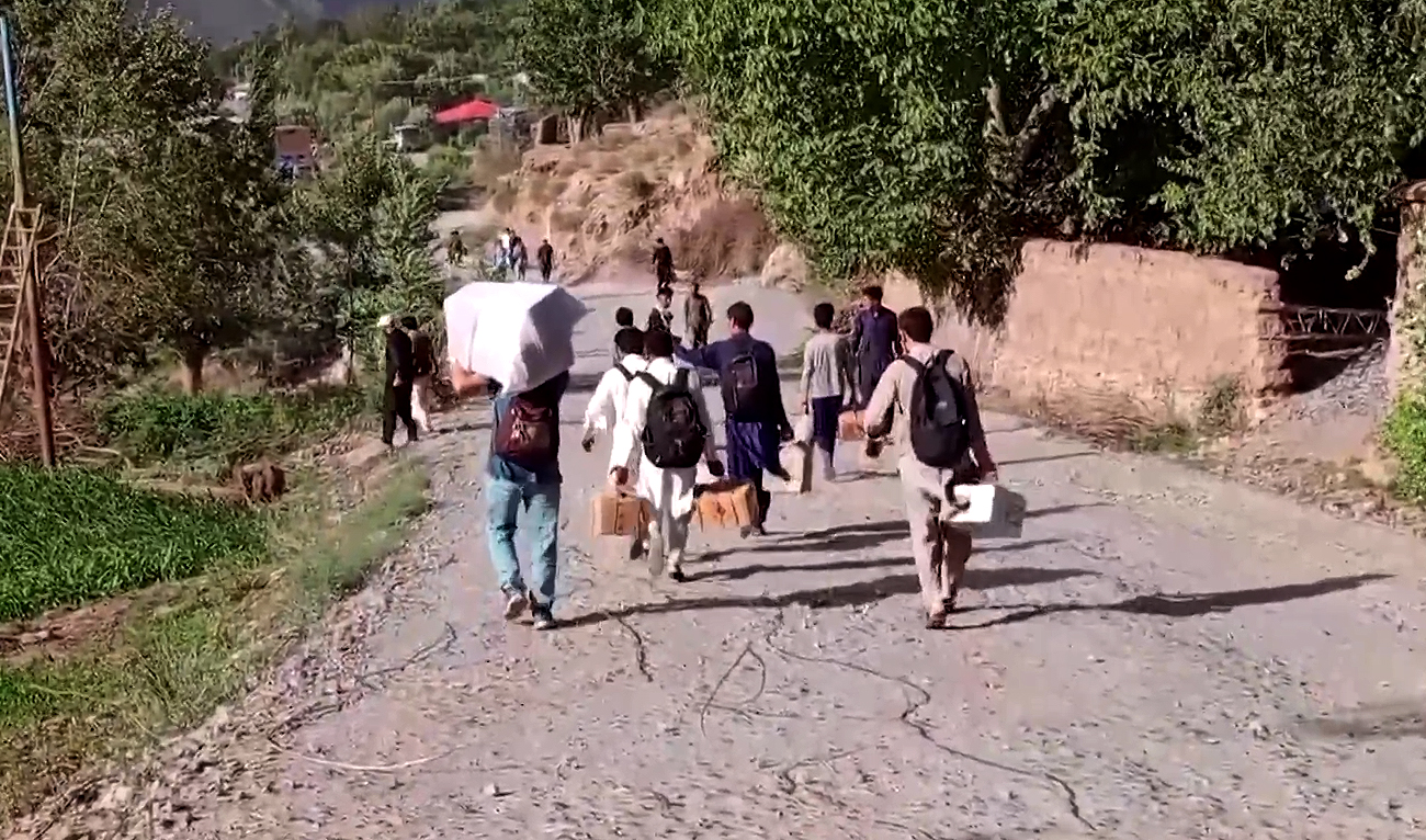Residents move carrying belonging from the flooded areas in Chitral, Pakistan on August 4, 2024. (Reuters/File)