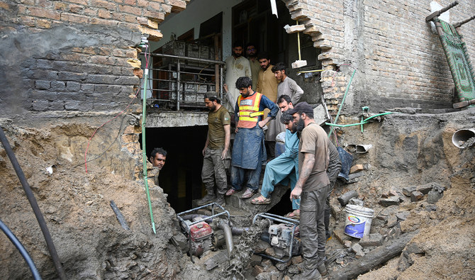 Rescue workers clean the basement of a house damaged by flash flood waters in Darra Adamkhel, Khyber Pakhtunkhwa province of Pakistan, on July 30, 2024. (AFP/File)