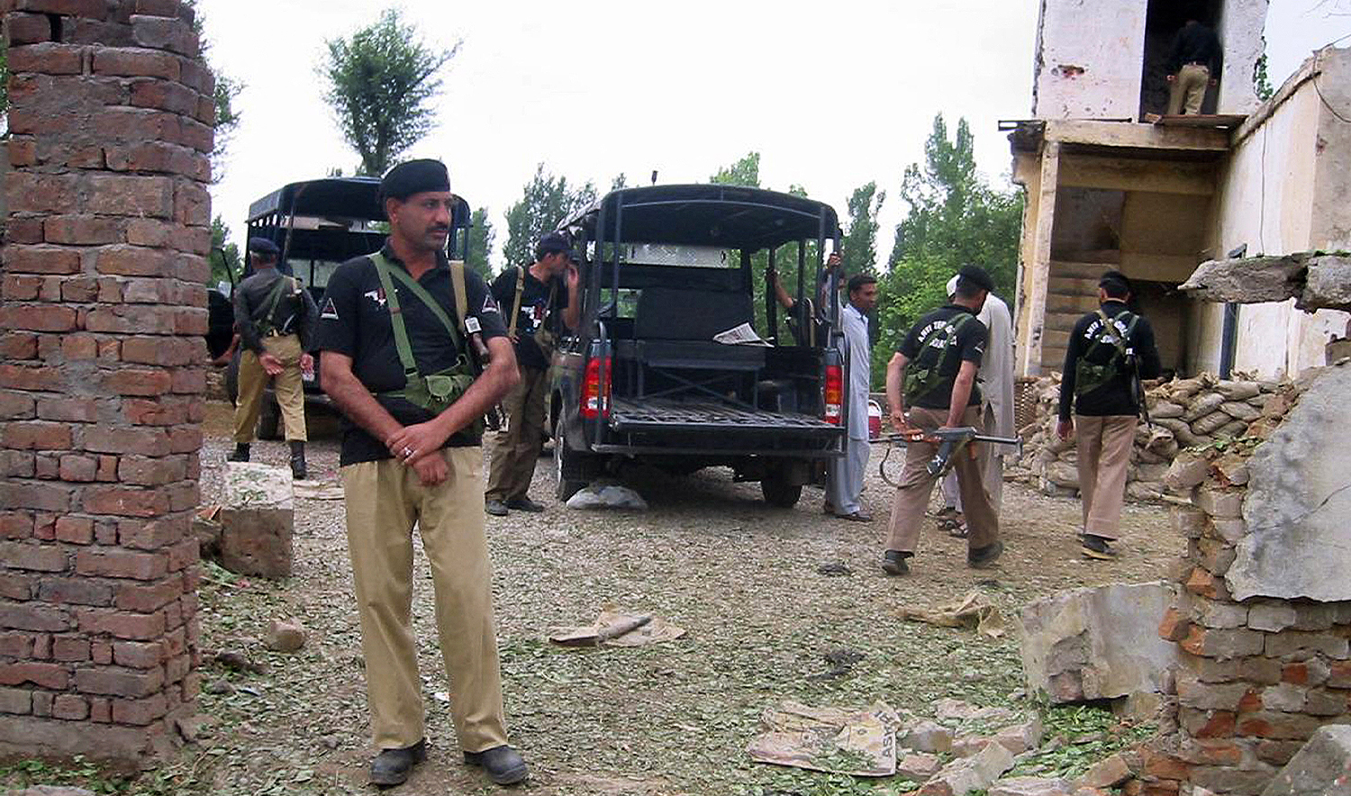 Pakistani policemen secure a damaged police checkpost after an attack in Mardan on June 16, 2009. (AFP/File)