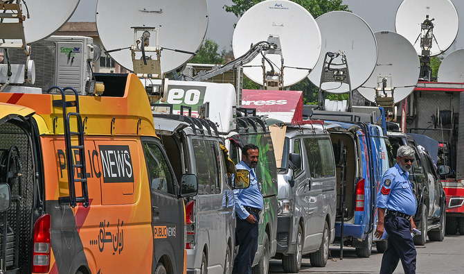 Police personnel stand guard in front of news media vans parked outside a special court in Islamabad on August 21, 2023. (AFP/File)