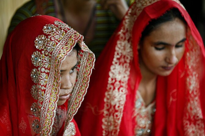 In this photograph taken on August 3, 2024 Shamila (L) and Salma Zameer, monsoon brides who were married underage look on at Khan Muhammad Mallah village, Dadu district in Sindh province. (AFP)