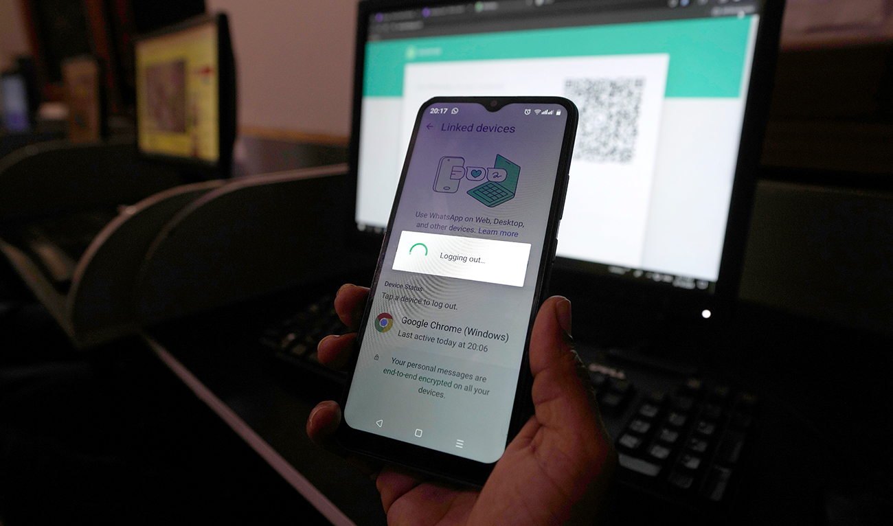 A Pakistani waits to connect his mobile WhatsApp with a desktop as internet runs slow past several days, in Karachi, Pakistan, Monday, Aug. 19, 2024. (AP)