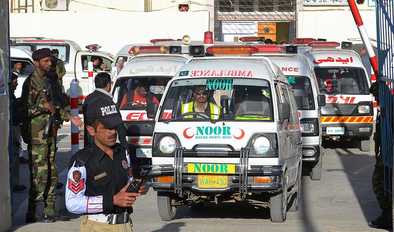 In this file photo, taken on October 25, 2016, Pakistani security personnel stand guard as an ambulance carrying the coffins of the 2016 suicide attack victims drives past in Quetta. (AFP/File)