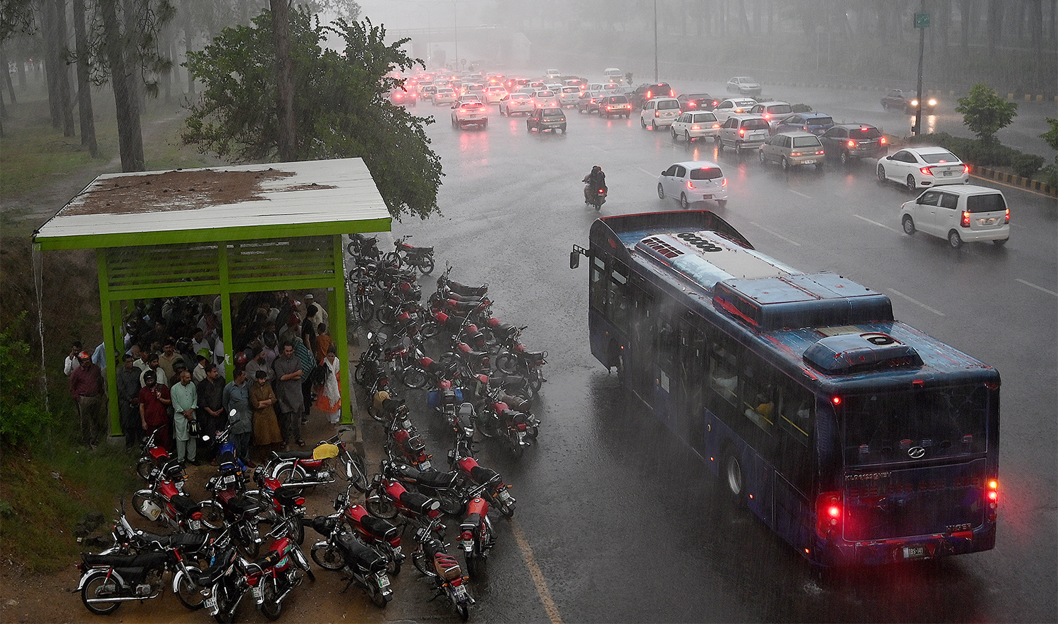 Commuters drive along a road amid heavy monsoon rains in Islamabad on July 10, 2024. (AFP/File)