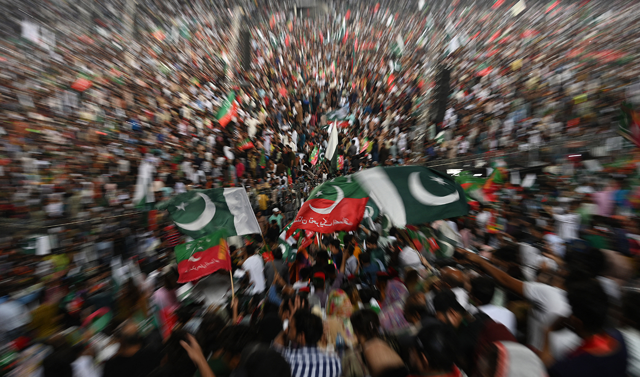 Supporters of Pakistan's former Prime Minister and Pakistan Tehreek-e-Insaf party (PTI) chief Imran Khan, wave flags during a rally to celebrate the 75th anniversary of Pakistan's independence day in Lahore on August 13, 2022. (AFP/File)