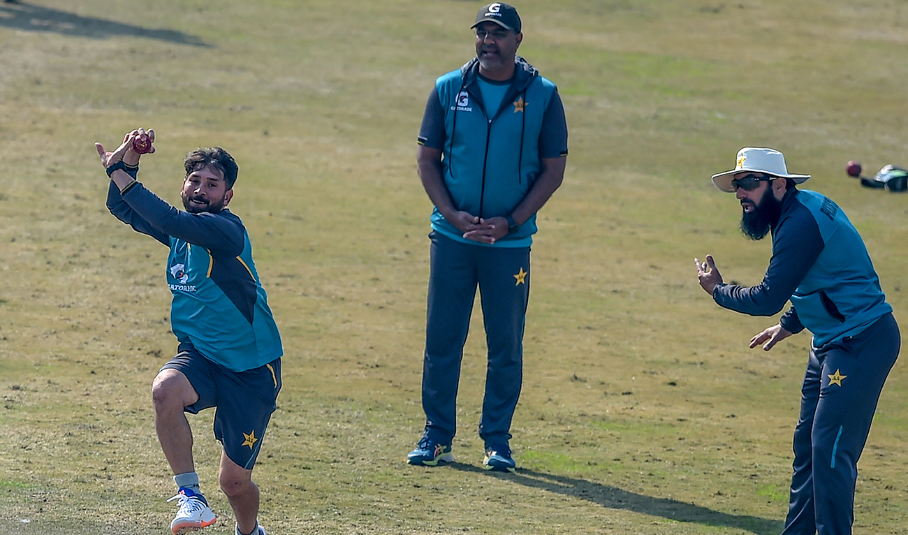 Pakistan's Yasir Shah (L) bowls as former team head coach Misbah ul-Haq (R) and former bowling coach Waqar Younis (C) look on during a practice session at the Rawalpindi Cricket Stadium in Rawalpindi on February 6, 2020. (AFP)