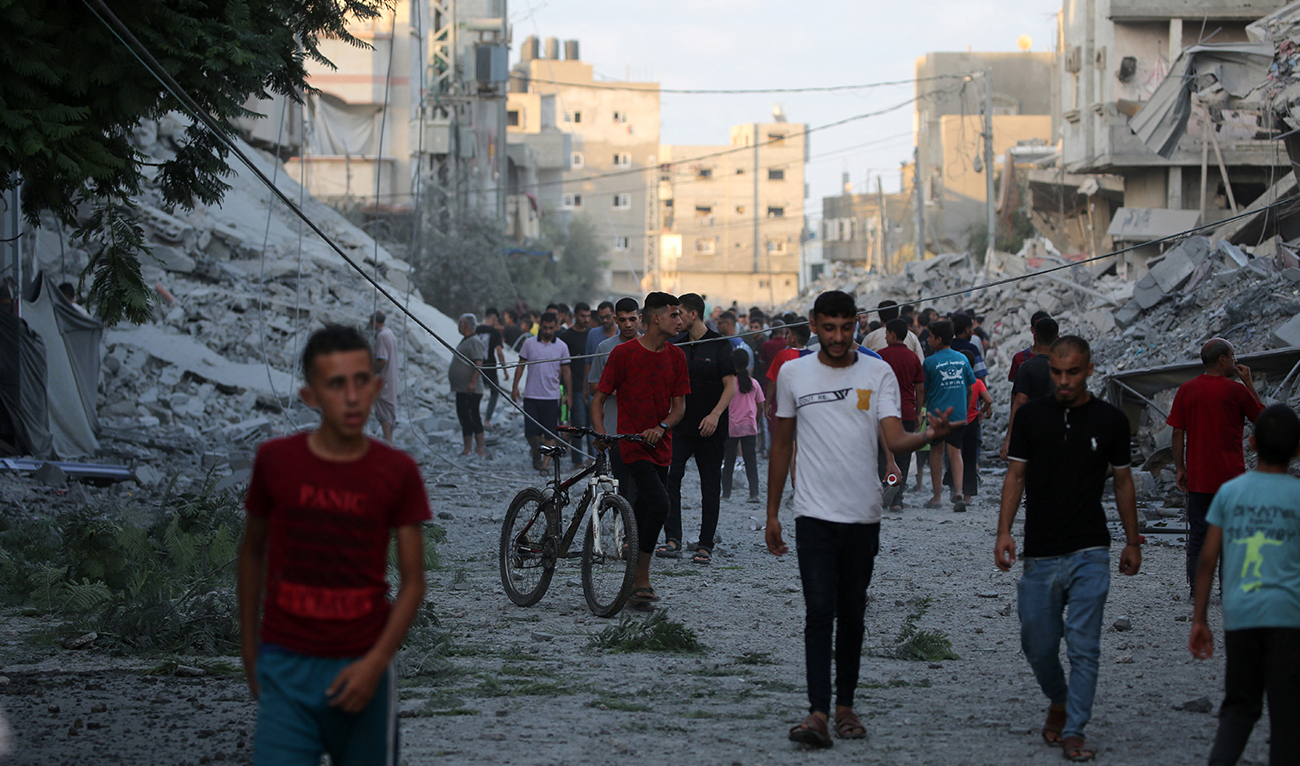 Palestinians gather to check a building shortly after it was levelled by Israeli bombing in the Nuseirat refugee camp in the central Gaza Strip on August 22, 2024. (AFP/File)