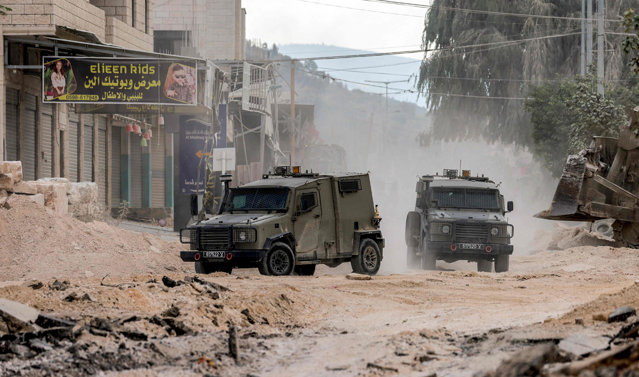 Israeli army armored vehicles move along a road during a military operation in Tulkarm in the north of the occupied West Bank on August 29, 2024. (AFP)