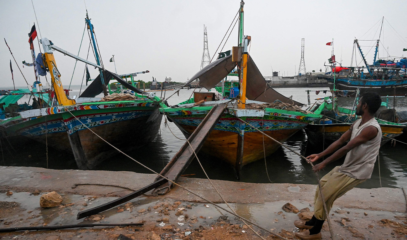 A fisherman moors his boat at Karachi Harbour, amid cyclonic winds in Karachi on August 29, 2024. (AFP)